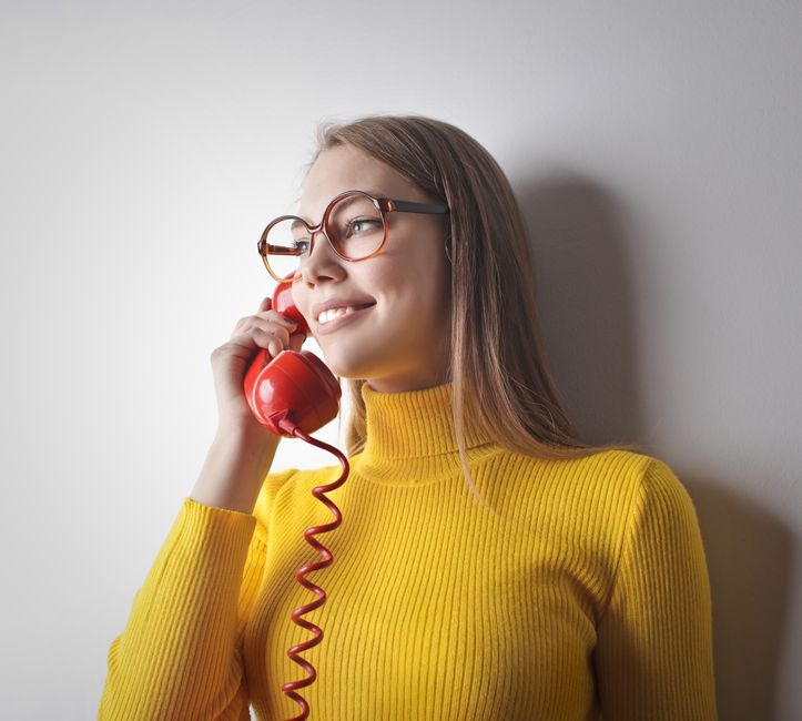 Osoba rozmawia przez telefon, sprawdzając skierowanie i dokumentację medyczną.