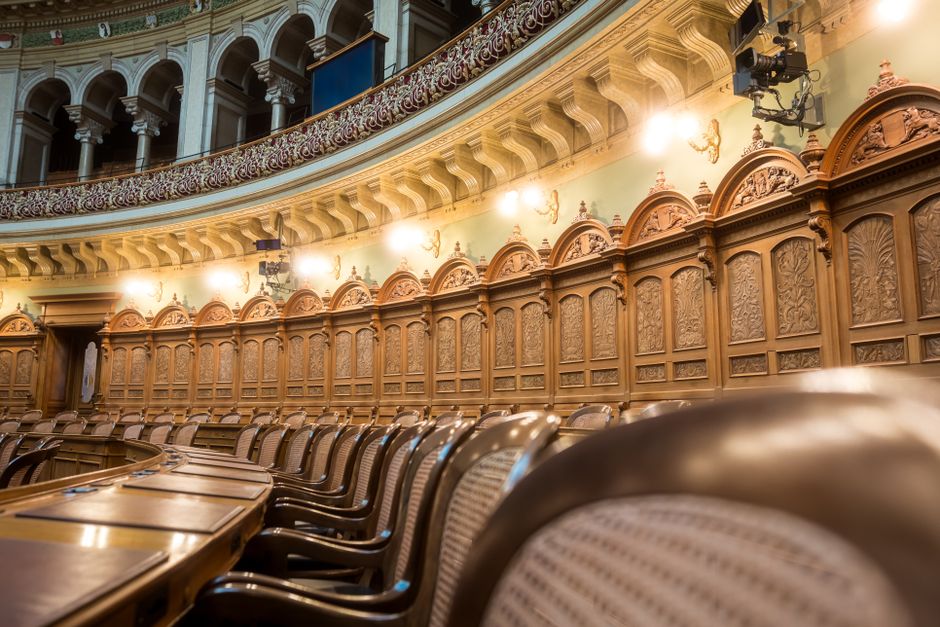 Posłowie uczestniczą w debacie w sali parlamentarnej.