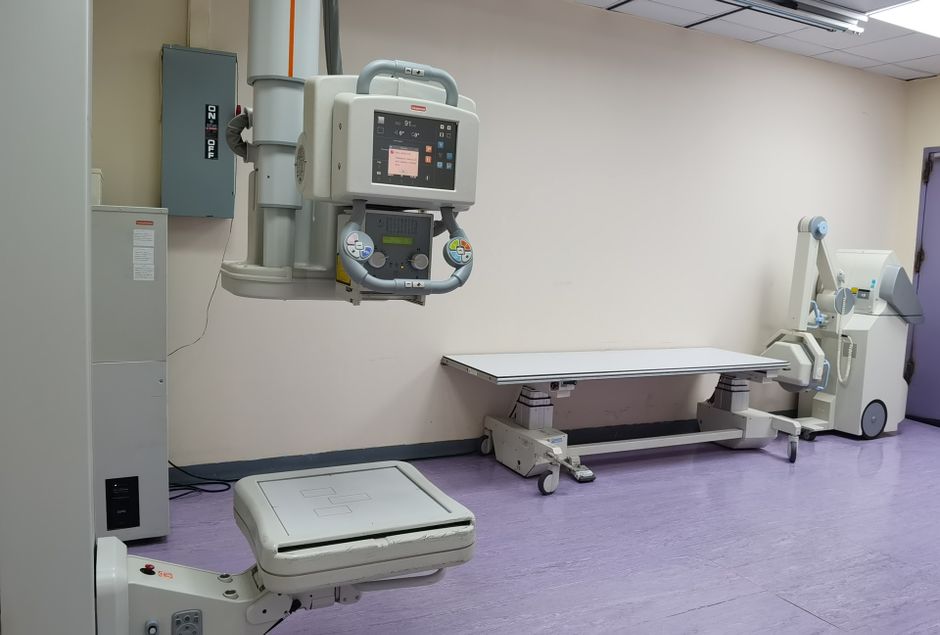 Pracownik pracowni radiologicznej ogląda obraz klatki piersiowej na monitorze.
