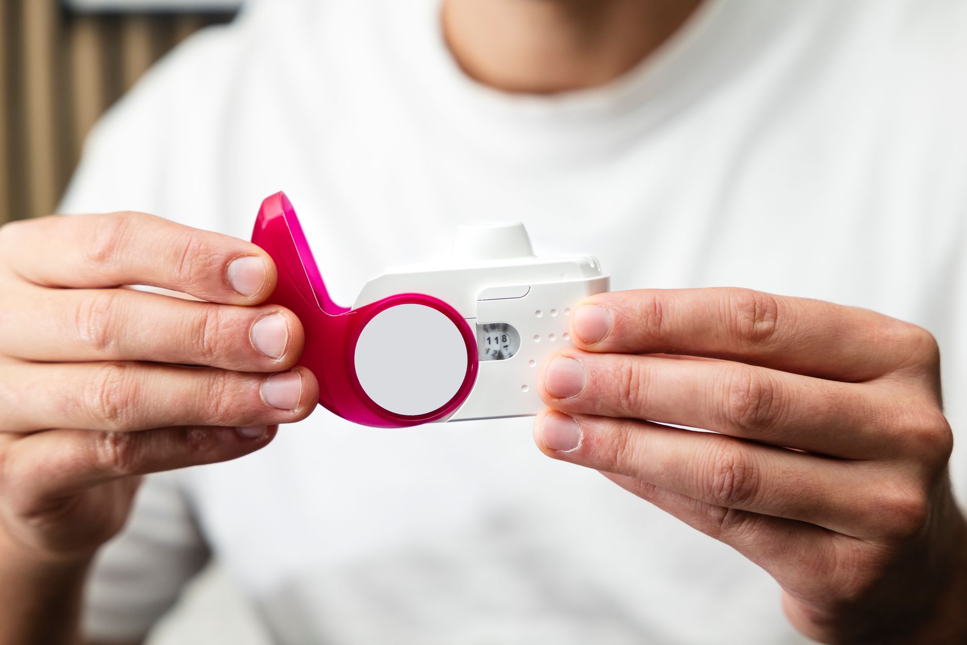 Osoba wykonująca test spirometrii pod okiem specjalisty w jasnym otoczeniu