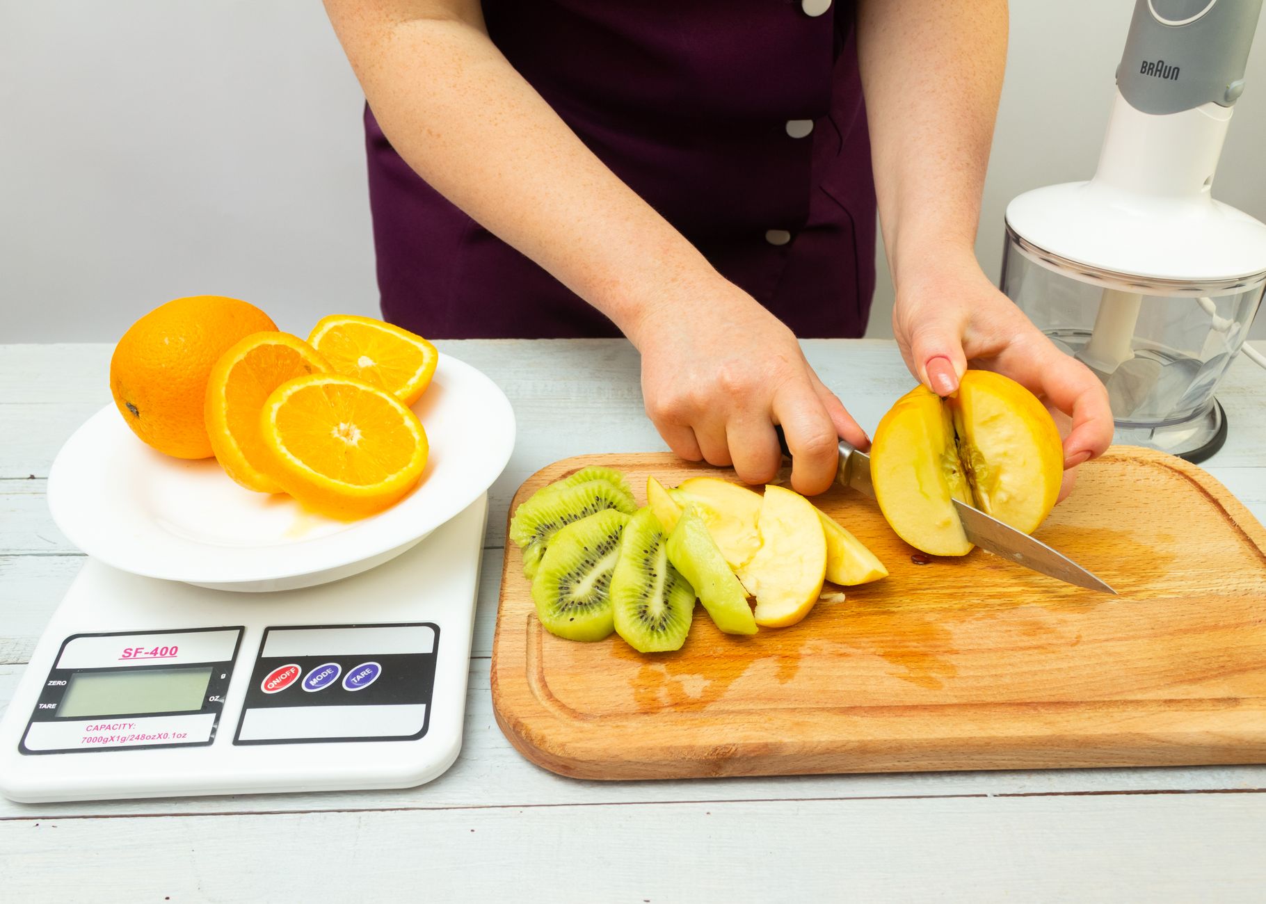 Kolorowe owoce na stole — awokado, jagody i cytrusy, obok notatnik i długopis