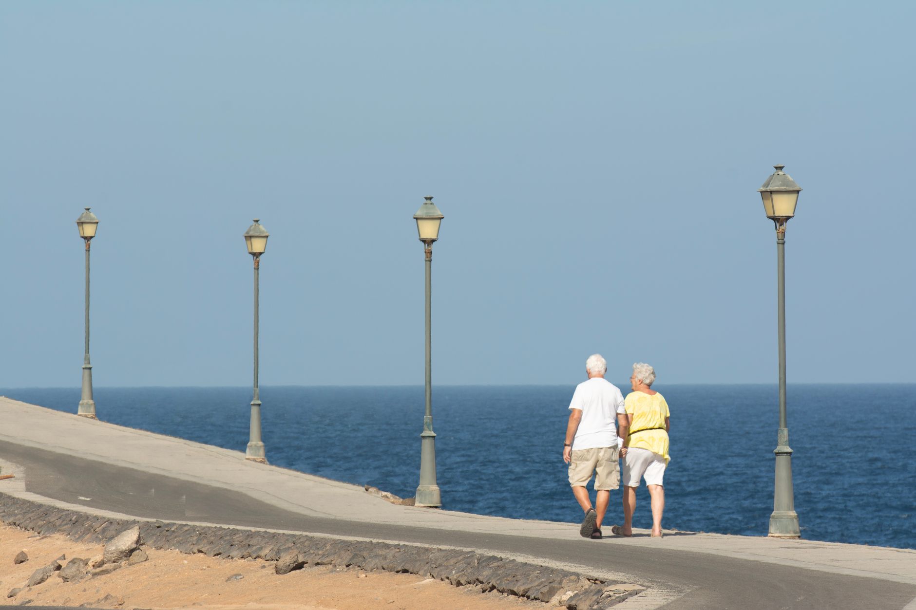 Aktywna para seniorów spacerująca w parku, uśmiechająca się i rozmawiająca