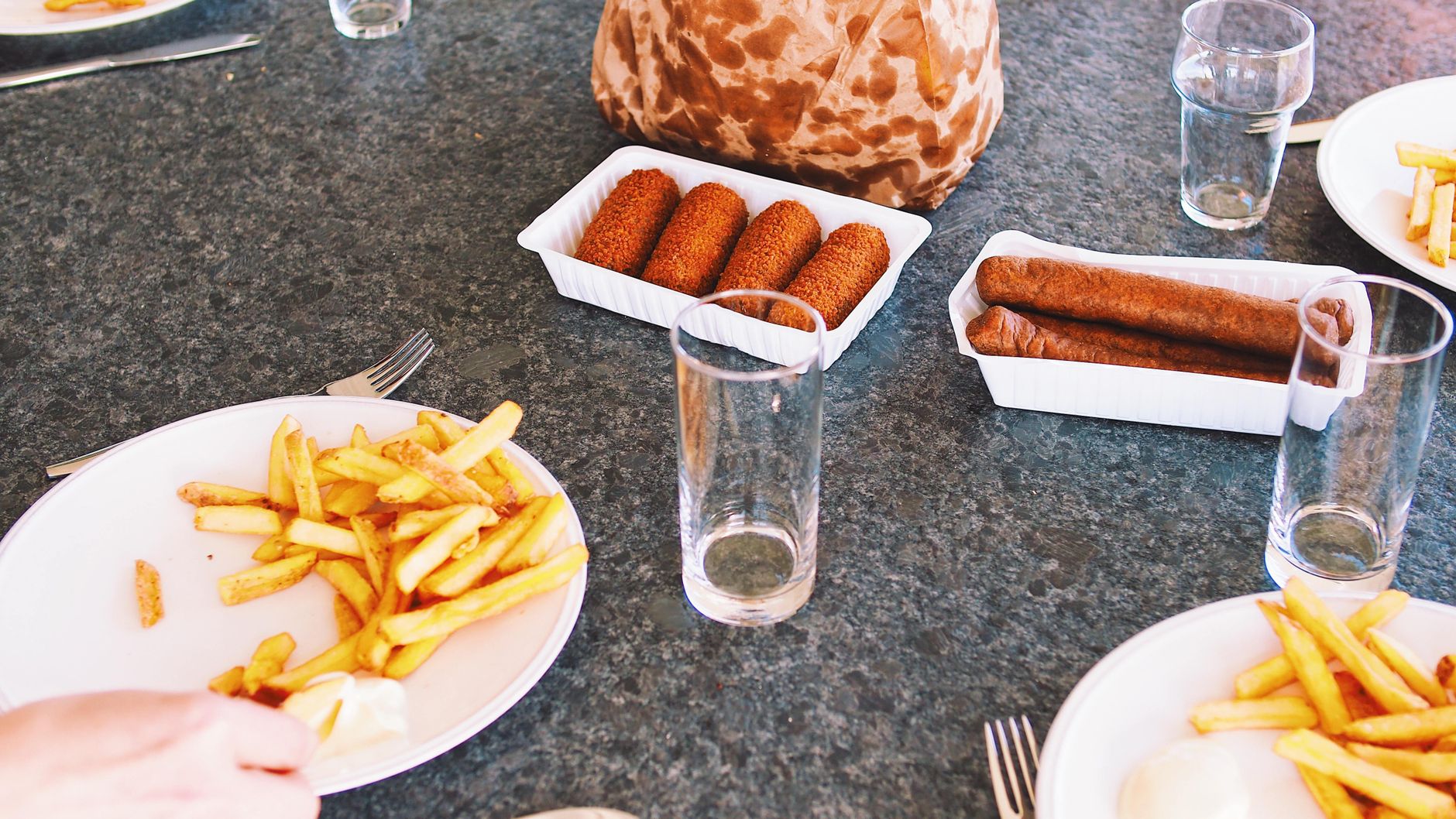 Stół zastawiony niezdrowym jedzeniem: fast food, słodycze i przetworzone posiłki