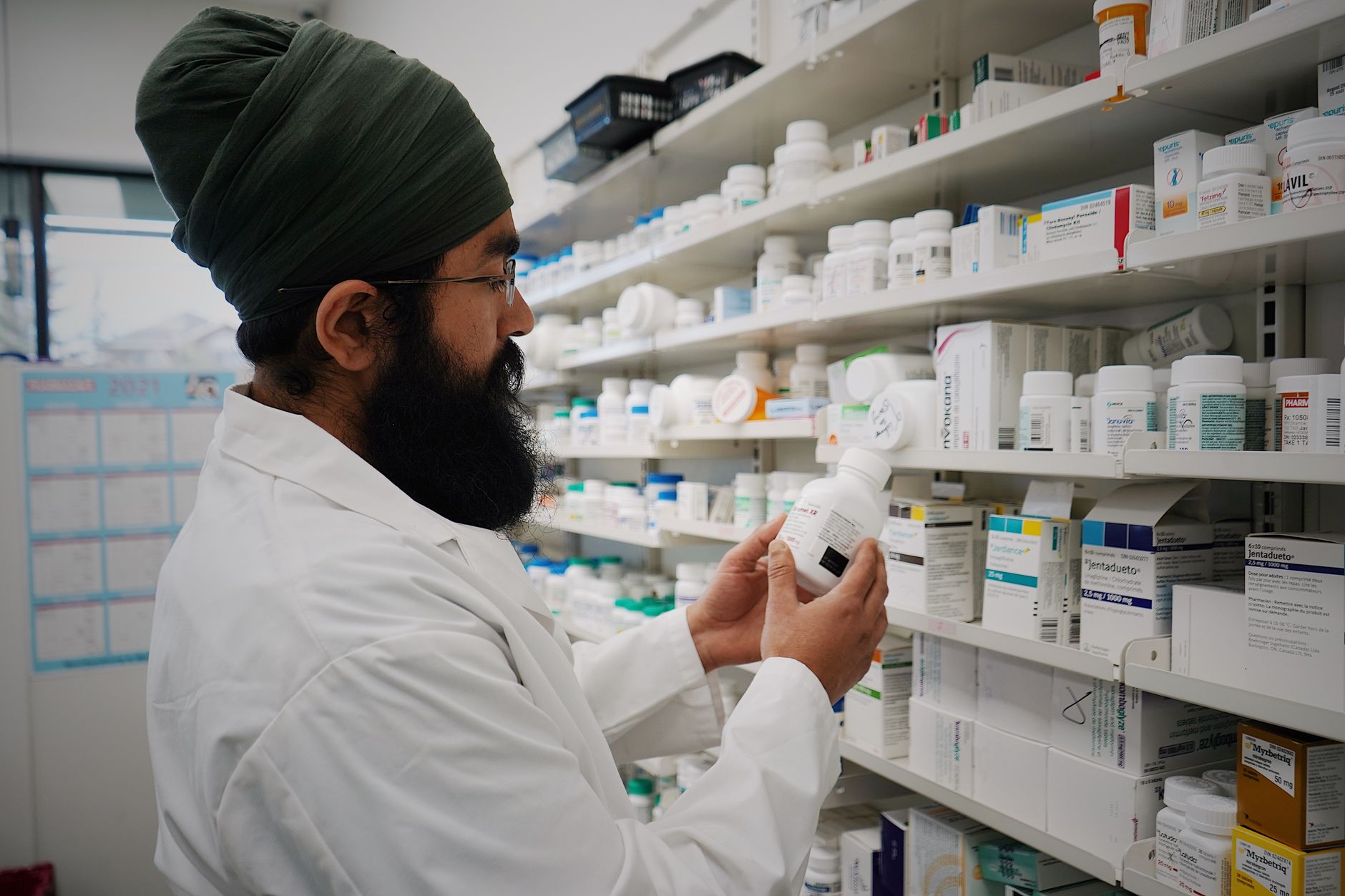 Farmaceuta sprawdza puste półki w aptece, ilustrując problem braku leków.