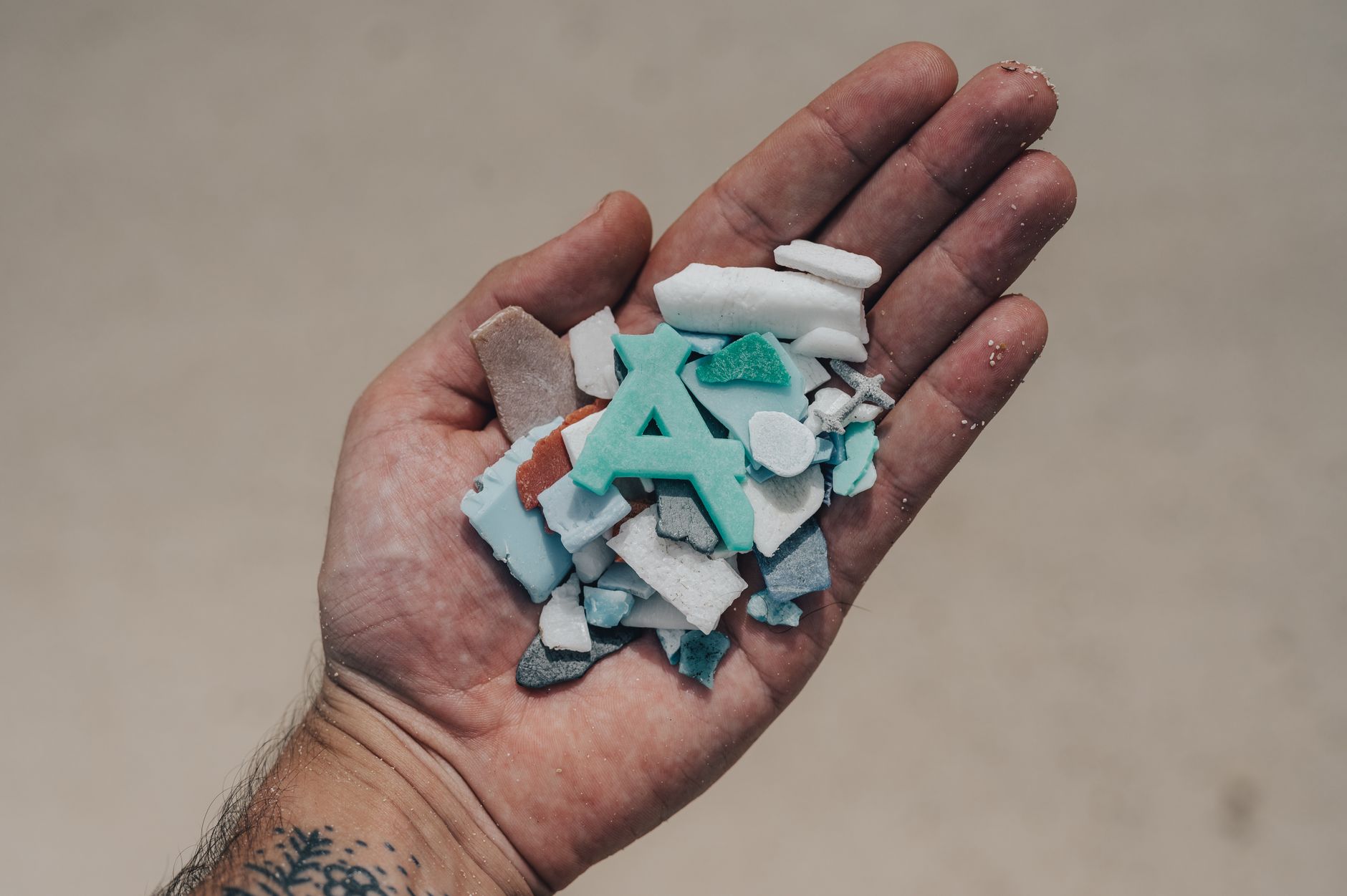 Bliskie ujęcie różnych plastikowych przedmiotów na drewnianym stole, podkreślające problem mikroplastiku