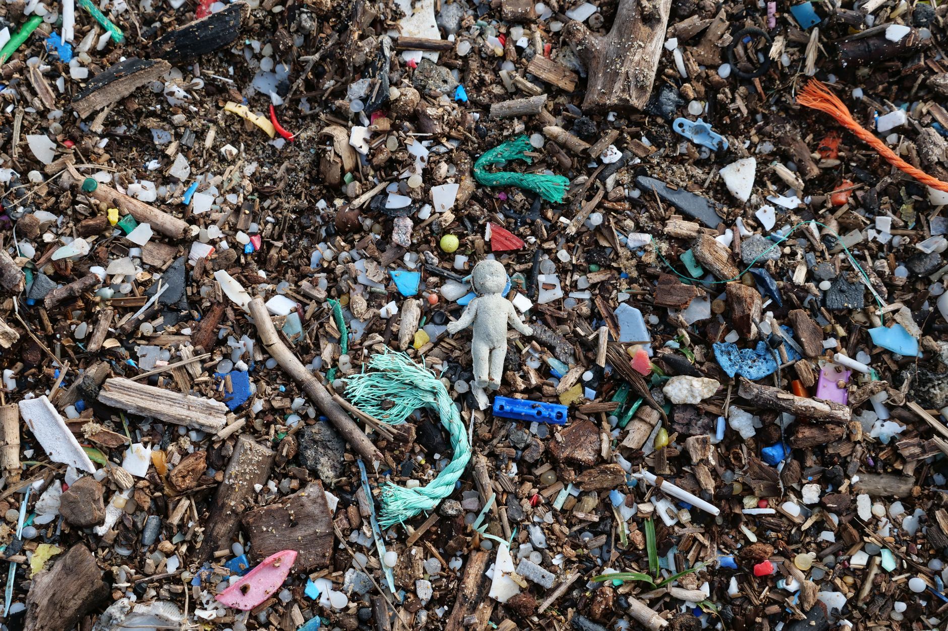 Plaża z kolorowym mikroplastikiem zmieszanym z piaskiem i kamykami