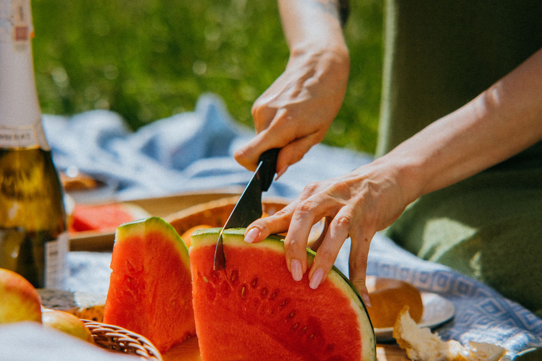 Zdrowy piknik na świeżym powietrzu z owocami, warzywami i wodą.