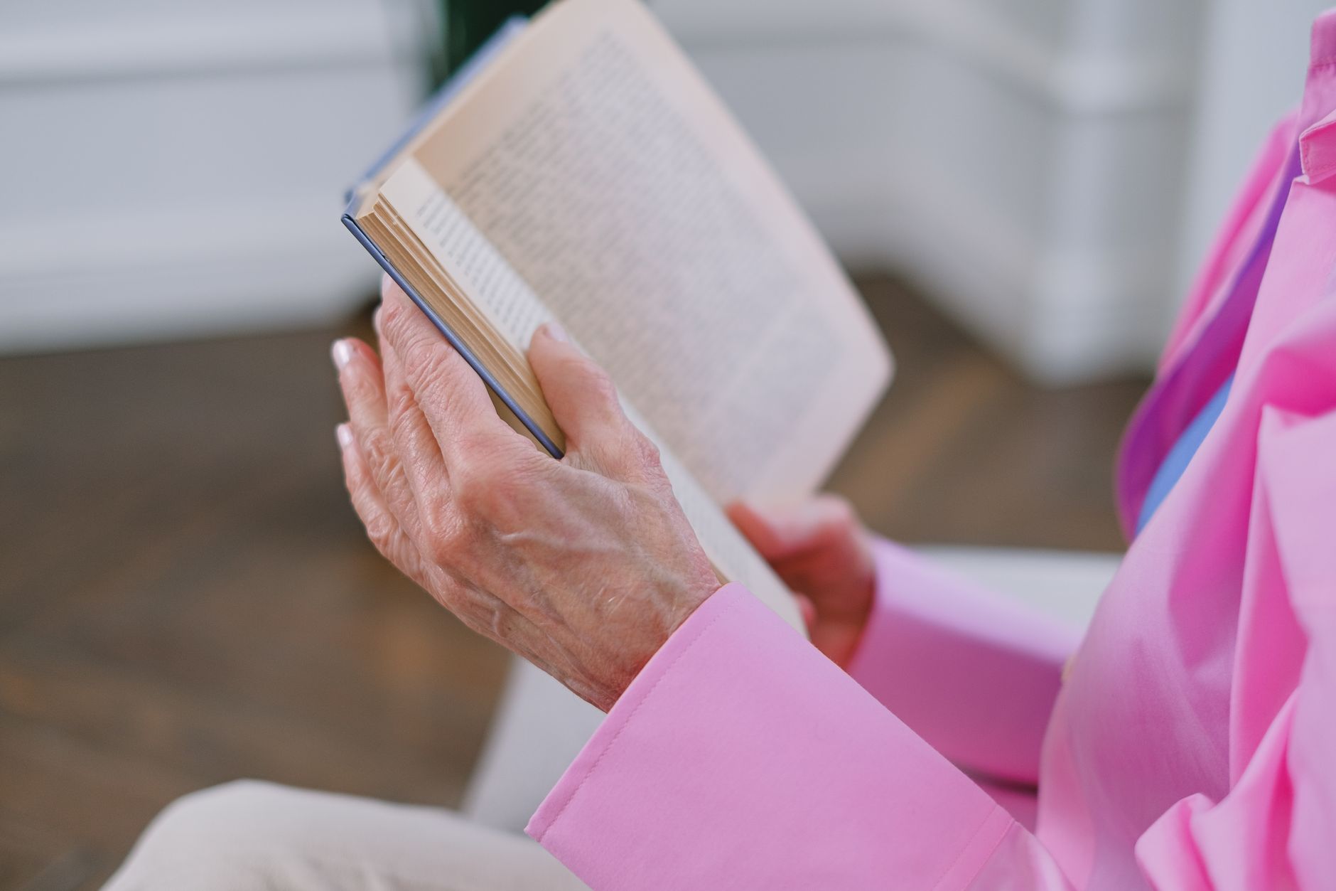 Starsza osoba czytająca książkę o demencji na ławce w parku
