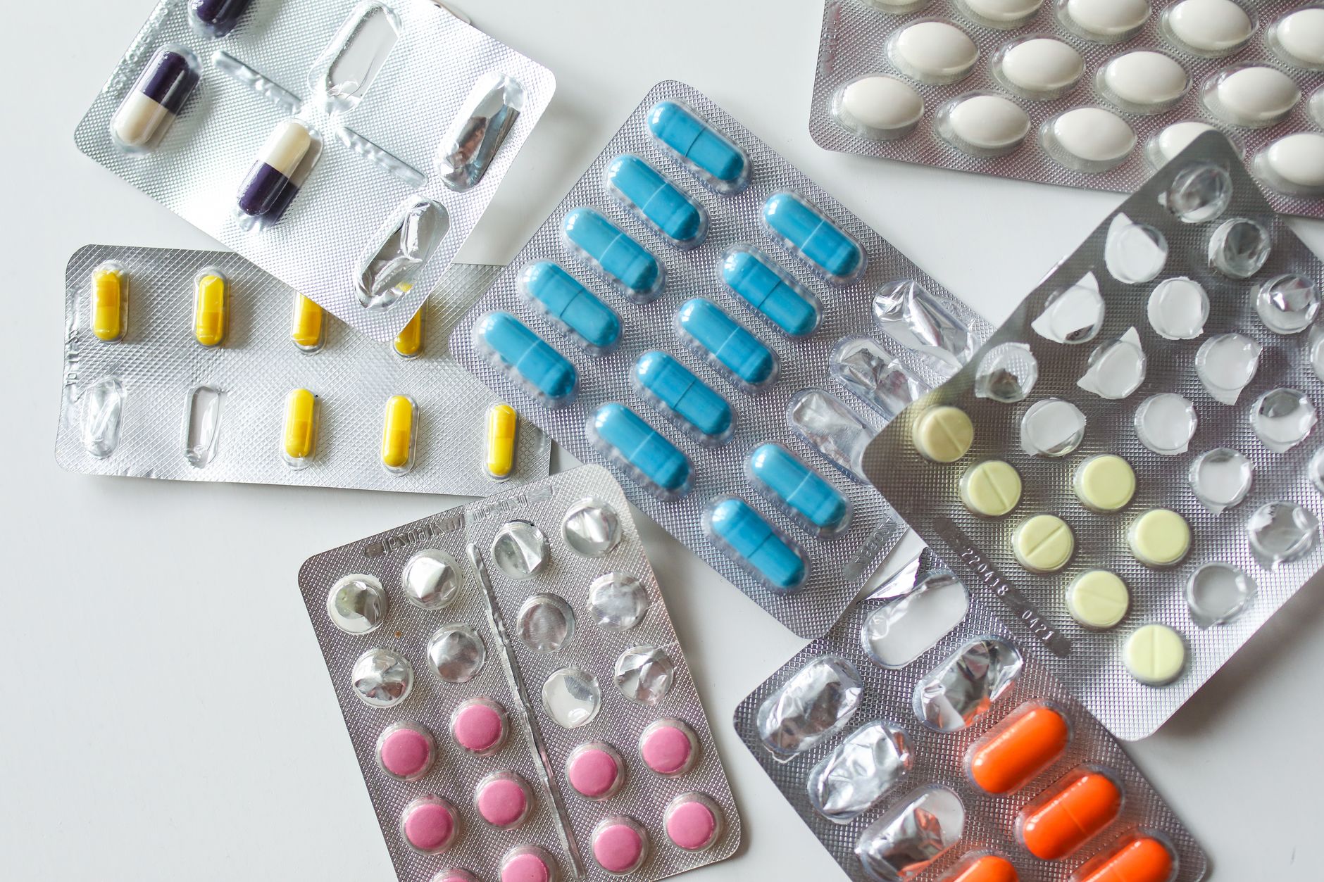 Farmaceuta sprawdza numer serii na opakowaniu leku przy ladzie aptecznej